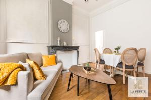 a living room with a couch and a table at Residence Belle Etoile in Valenciennes