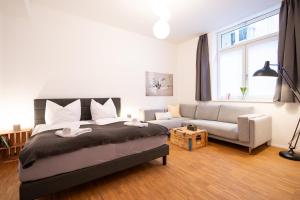 um quarto com uma cama e um sofá em Ko-Living - Beatles und Banksy Suites & Studios am Eselsbrunnen - Altstadt - Küche em Halle an der Saale