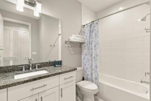 a bathroom with a sink and a toilet and a tub at NEW! Canopy Cabana - Luxury Downtown Apartment in Safety Harbor