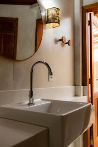 a sink in a bathroom with a mirror at Pousada Valhacouto in Paraty