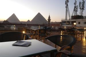 een uitzicht op de piramides vanuit een restaurant met tafels en stoelen bij Loca Pyramids View in Caïro