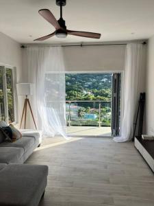 a living room with a couch and a ceiling fan at Modern condo close to Rodney Bay and Airport in Gros Islet