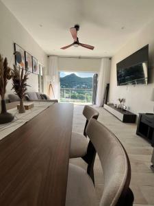a living room with a table and chairs and a ceiling fan at Modern condo close to Rodney Bay and Airport in Gros Islet