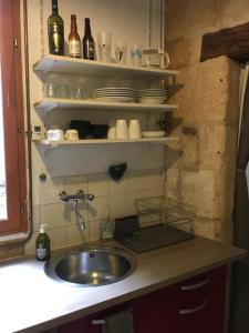uma cozinha com um lavatório e um balcão com pratos em Appart sympa dans le vieux Nimes em Nîmes