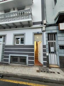 a white and black building with a door at Céntrico apartamento in Santa Cruz de Tenerife