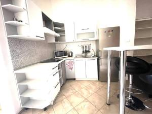 a small kitchen with white cabinets and a table at Apartment Elizabeth 2 in Košice +2 photos