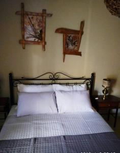 um quarto com uma cama com almofadas brancas e 2 janelas em Iris Deluxe 4 em Kavala