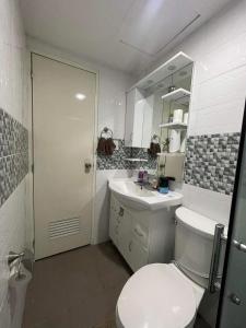 a white bathroom with a toilet and a sink at Camella Cerritos Gensan in General Santos