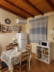 eine Küche mit einem Tisch und einem weißen Kühlschrank in der Unterkunft Il Gelsomineto dell'Etna in Nicolosi