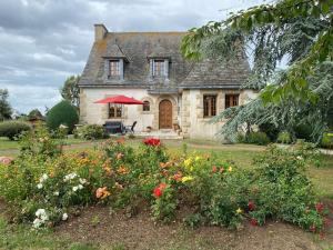 a house with flowers in the front yard at Grande maison de campagne in Lantic
