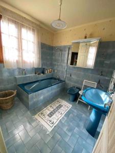 een badkamer met een bad, een toilet en een wastafel bij Grande maison de campagne in Lantic