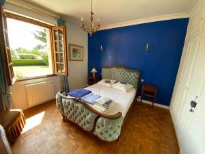 a bedroom with a bed with a blue wall at Grande maison de campagne in Lantic