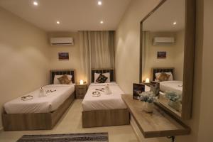 een hotelkamer met 2 bedden en een spiegel bij Loca Pyramids View in Caïro