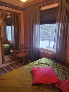 a bedroom with a bed and a window and a chair at Villa Onnela Ämttöö in Pori