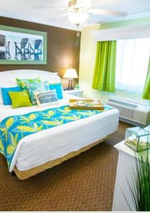 1 dormitorio con 1 cama grande con almohadas azules y amarillas en 1BR Deluxe Grand Palms Resort Free Shuttle service, en Myrtle Beach