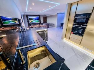 uma cozinha com um lavatório e uma sala de estar em Luxury City Stay: 2-BR Penthouse em Wolverhampton