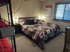 a bedroom with a bed with a comforter on it at Table Rock Resorts at Indian Point in Branson