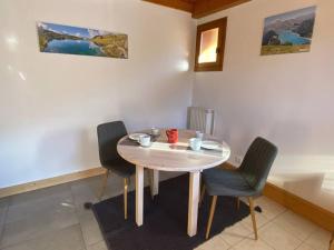 a dining room table with two chairs and a table at Appartement à Queige in Queige