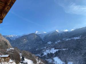 a view of a snow covered mountain range with trees at Appartement à Queige in Queige
