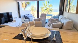 a table with a plate and two wine glasses on it at Boutelou playa con vistas al mar in Sanlúcar de Barrameda