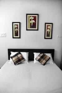 a bedroom with a bed with three pictures on the wall at Raaga Home in Udaipur