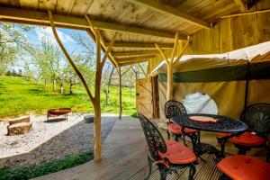 a patio with a table and chairs on a deck at Torre Cider Farm in Washford