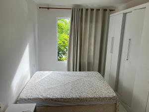 a bedroom with a bed and a window at Condominio reserva imbassai in Mata de Sao Joao