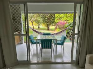 uma sala de jantar com uma mesa e cadeiras numa varanda em Condominio reserva imbassai em Mata de São João