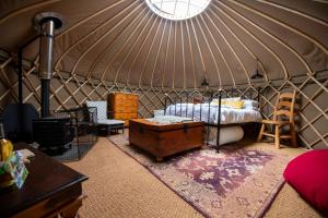 a room with a bed and a table in a yurt at Torre Cider Farm in Washford