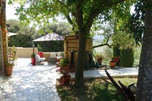 a garden with a tree and a patio at Le Grand Saint Paul in Rognes +7 photos