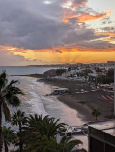 Blick auf den Strand bei Sonnenuntergang mit Palmen in der Unterkunft Apartamento cerca de la playa in Maspalomas
