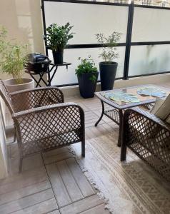um pátio com duas cadeiras, uma mesa e vasos de plantas em Cozy Apartment Near the Train Station em Rueil-Malmaison