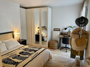 a bedroom with a bed and a desk in it at Cozy Apartment Near the Train Station in Rueil-Malmaison