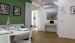 sala de estar con mesa blanca y pared verde en Casa D'Antò, en Petralia Sottana