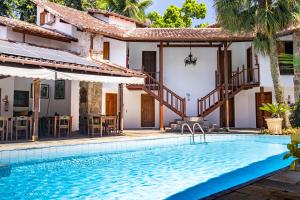 eine Villa mit einem Pool vor einem Haus in der Unterkunft Pousada Valhacouto in Paraty