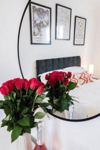 a bedroom with a mirror and red roses on a table at Fantastic 2 Bed 2nd Floor Flat in Reading