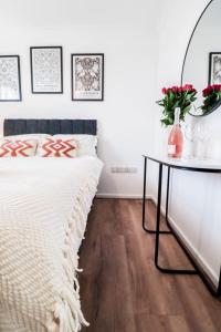 a bedroom with a bed and a table with flowers at Fantastic 2 Bed 2nd Floor Flat in Reading