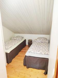 two beds in a room with a ceiling at Gold Digger's Timber in Inari
