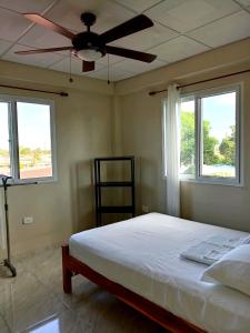 1 dormitorio con ventilador de techo y 2 ventanas en Habitación privada a 8 minutos del Aeropuerto Tocumen en Tapia Número Dos
