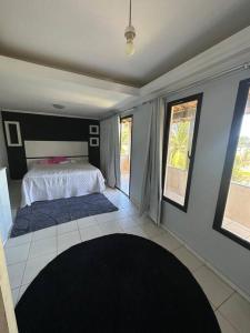 um quarto com uma cama com paredes e janelas azuis em Casa em frente a praia em Vila Velha