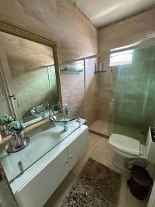 uma casa de banho com um lavatório, um WC e um espelho. em Casa em frente a praia em Vila Velha