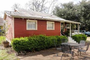 a small red house with a table in front of it at Wensel Cottage in downtown Natchez in Natchez
