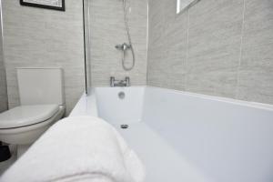 a bathroom with a white tub and a toilet at Sedgemoor in Stockton-on-Tees