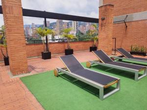 un gruppo di sedie a sdraio sul tetto di Orange Suites by Vibra Bonita a Medellín Altre 8 foto