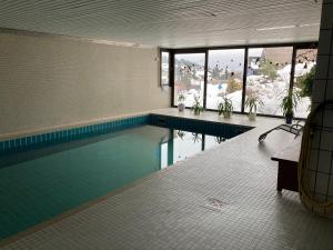 a swimming pool in a building with a pool at Apartment Henri in Schönwald