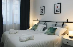2 letti in una camera da letto con lenzuola e cuscini bianchi di Casa D'Antò a Petralia Sottana