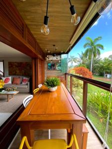 a dining room with a wooden table and yellow chairs at EXCLUSIVE RESIDENCE, BARRA GRANDE, PENINSULA DE MARAÚ in Barra Grande