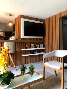 a living room with a television on a wooden wall at EXCLUSIVE RESIDENCE, BARRA GRANDE, PENINSULA DE MARAÚ in Barra Grande +8 photos