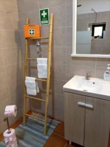 uma casa de banho com uma escada de toalha ao lado de um lavatório em Snow Guest House em Santarém