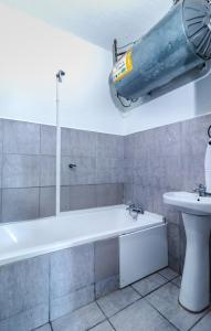 a bathroom with a bath tub and a sink at Wavecrest 103 Holiday Apartment in Durban